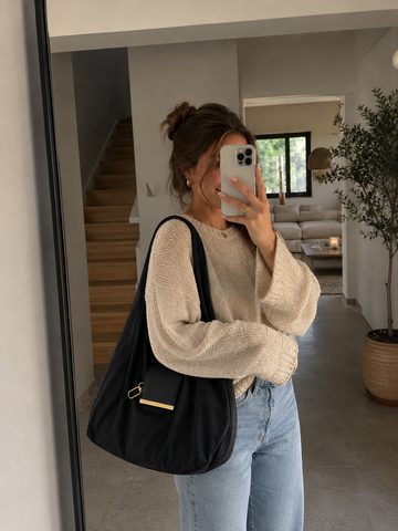 Schwarze Varelli an der Schulter zu Jeans und hellem Pullover
